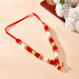 Red white floral rakhi with gold accents on 12 inch idol mala garland
