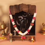 Ornate 12-inch Lord Ganesha statue on wooden altar with white red satin garland