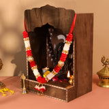 Dark wood altar with carved archway, red white garlands, gold beads, 12 inch idol mala