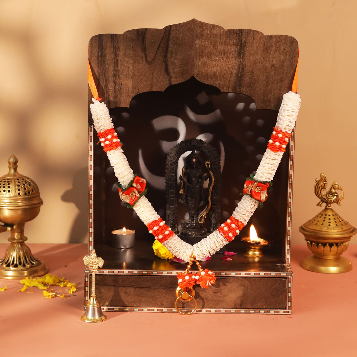 Wooden altar with ornate deity statue and orange white floral garland