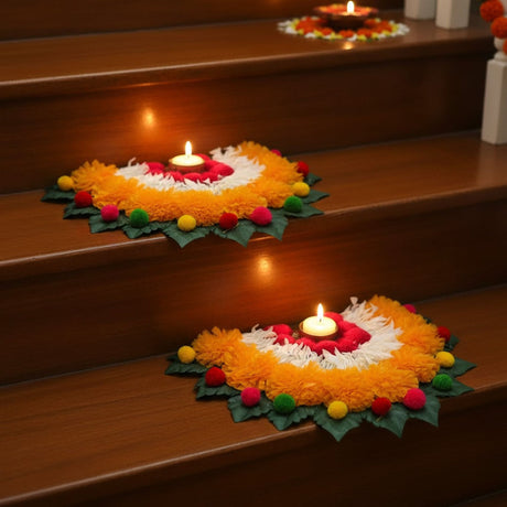 Semi-circle Rangoli mat with orange marigold garland, green leaves, and tea light holders for Diwali pooja decor