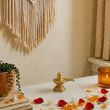 Golden brass shiva lingam statue with intricate engravings and small inscription for hindu pooja and home temple decor