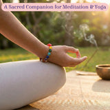 LOVENSPIRE 7 Chakra Rudraksha Bracelet with rainbow stones on wrist meditating