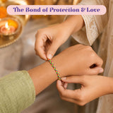 A colorful handmade minimalist rakhi bracelet with red green and yellow threads being placed on a wrist