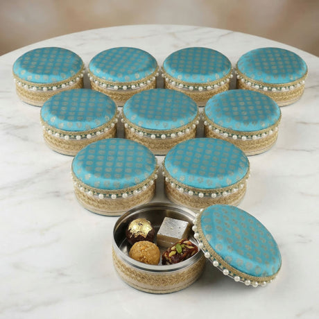 Turquoise blue fabric covered steel ladoo boxes with gold embroidery and pearl trim perfect for holi and diwali gifts