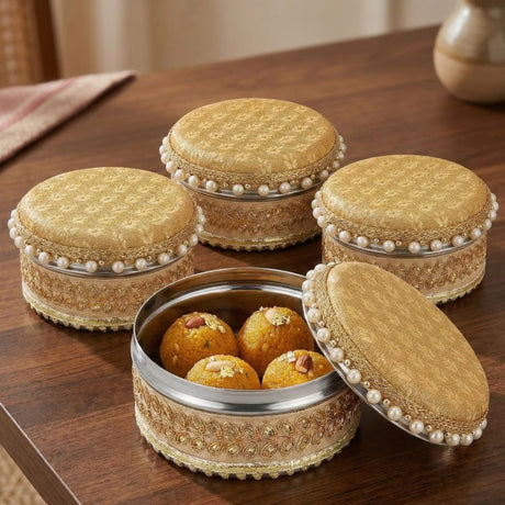 Golden intricately embroidered fabric lids with pearl embellishments on stainless steel 4 ct ladoo box for festivals