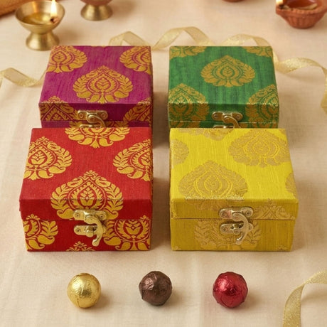 Four ornate square small gift boxes in purple green red and yellow with gold damask brocade and silver clasps for weddings