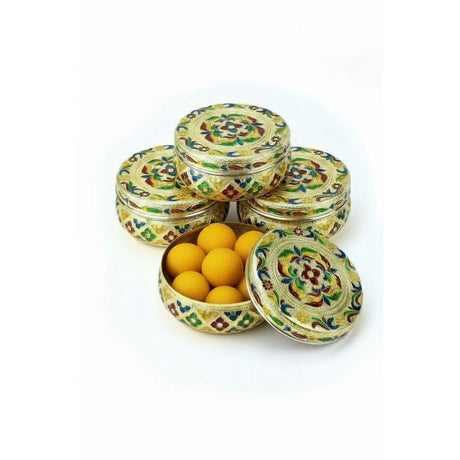 Golden round tin with colorful floral design filled with yellow candies for gift and storage