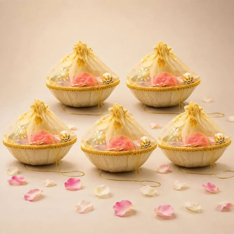 Beige woven 6 inch handmade gift basket with gold-trimmed sheer organza lid holding pink roses for Indian celebrations