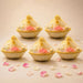 Beige woven 6 inch handmade gift basket with gold-trimmed sheer organza lid holding pink roses for Indian celebrations