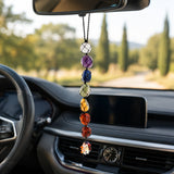 A seven-chakra-colored tumbled gemstone crystal car hanging ornament with black cord and flower charm for spiritual decor