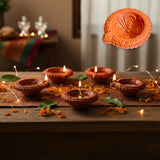 Traditional handmade terracotta diya set with lit wicks on wood
