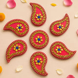 Vibrant red paisley acrylic diya floor rangoli decorated with gold beads and blue gemstone for diwali and navratri decor