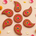Vibrant red paisley acrylic diya floor rangoli decorated with gold beads and blue gemstone for diwali and navratri decor