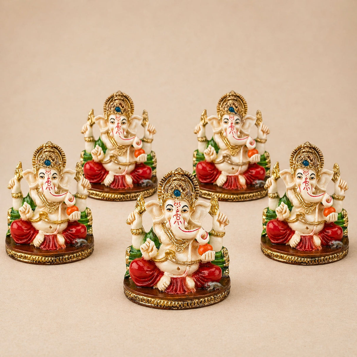 Set of five ornate cream acrylic ganesha idols with red green accents and gold detailing for home temple and festival decor