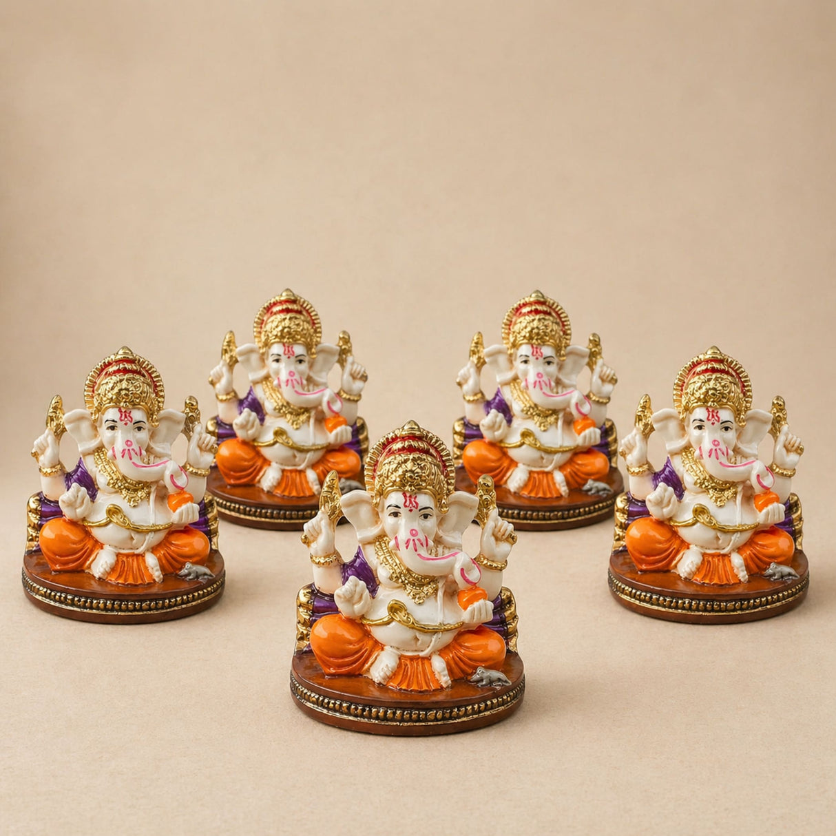 Set of five ornate white and orange acrylic ganesha idols with gold accents seated on decorative bases for home temple and festival decor