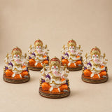Set of five ornate white and orange acrylic ganesha idols with gold accents seated on decorative bases for home temple and festival decor