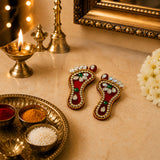 Acrylic lakshmi charan paduka feet in red and gold embellished with crystals and green stones for diwali decoration
