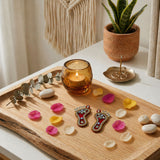 Amber glass candle holder with lit candle beside acrylic lakshmi charan paduka feet for diwali home temple decoration