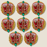 Acrylic Lakshmi Charan Paduka feet adorned with red and gold designs, green gemstones, and silver beads for Diwali decor