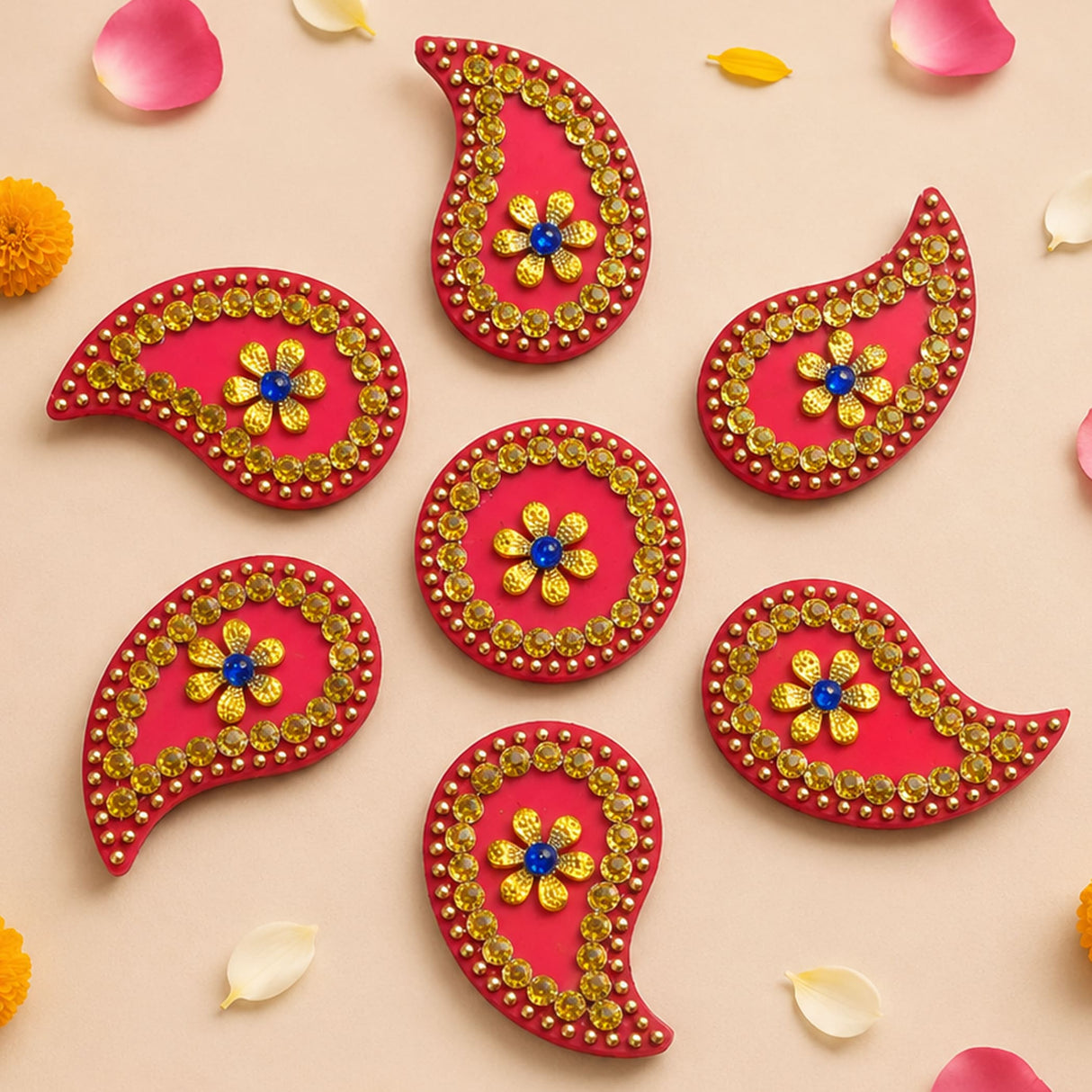 Acrylic rangoli set featuring vibrant red paisley decorative stickers with gold beads and central blue gemstone flower