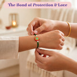 A vibrant green handmade animal theme rakhi with a colorful flower charm in red and white for brother’s protection