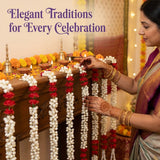 Woman with henna hands and gold bangles arranges artificial jasmine rose garlands on altar