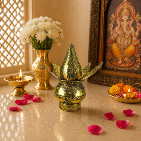 Golden intricately engraved metal artificial mangal kalash with pointed top and leaf-like extensions for wedding puja decor