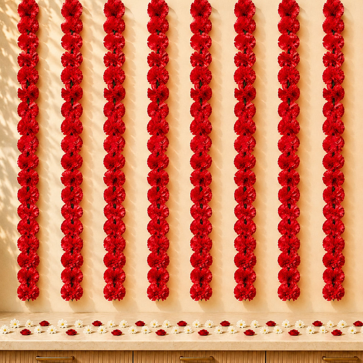 Red artificial carnation garlands hanging vertically as marigold strings for diwali and pooja decoration backdrop