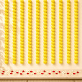 Rows of vibrant yellow artificial marigold strings arranged in neat vertical lines for diwali and pooja decoration