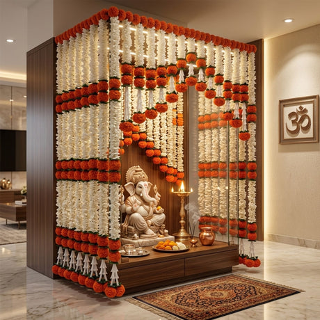 A white marble ganesh idol seated on a wooden altar adorned with 2 strings artificial orange and white marigold garland bandhanwar