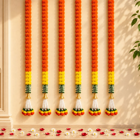 Artificial marigold garland with vibrant orange yellow flowers green accents and gold tassels for festive decorations