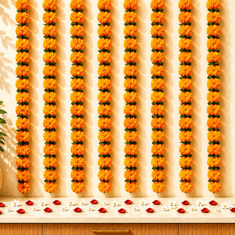 Artificial vibrant orange marigold and mango leaf garlands with green leaves for diwali decoration and indian weddings