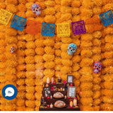 Artificial marigold garland with sugar skull decorations and papel picado flags for celebrations