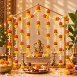 Golden ganesha idol seated on ornate pedestal with vibrant orange and yellow artificial marigold and tuberose garlands