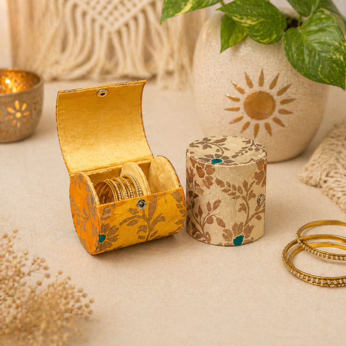 Golden bangles nestled inside a vibrant yellow floral-patterned fabric bangle box organizer for wedding and travel use