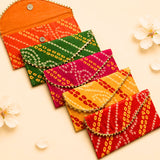 Vibrant brocade fabric money envelopes in orange green pink yellow and red with gold trim for indian wedding and gifting