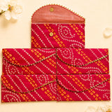 Brocade fabric money envelopes in vibrant red and orange with gold trim featuring decorative bandhani pattern