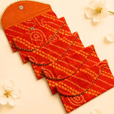 Vibrant red brocade fabric money envelopes with gold bandhani pattern and metallic button closures for cash gifts and savings