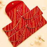Red brocade fabric envelope with orange white geometric patterns gold trim and metallic buttons for cash gift holder