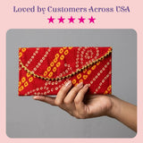 A vibrant red brocade fabric money envelope with yellow white geometric pattern and gold trim for indian wedding gifts