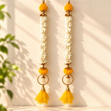 Golden metal bangle pom pom hanging backdrop adorned with white marigold flowers orange pom poms and yellow tassels for festive decor