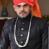 Black silk sherwani with gold buttons and handmade pearl necklace from Barati Swagat Mala Set