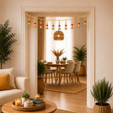 Bead door toran with golden bell garland and red pompom accents hanging above dining area for festive decor