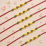Yellow and gold beaded designer bead rakhi with intricate metalwork on red thread for brother and bhabhi protection gift