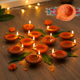 Traditional handmade terracotta diya with floral carvings, warm orange hue