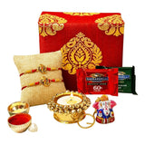 Red and gold ornate paisley gift box from Bhai Dooj hamper with rudraksha rakhi bracelet set and traditional items
