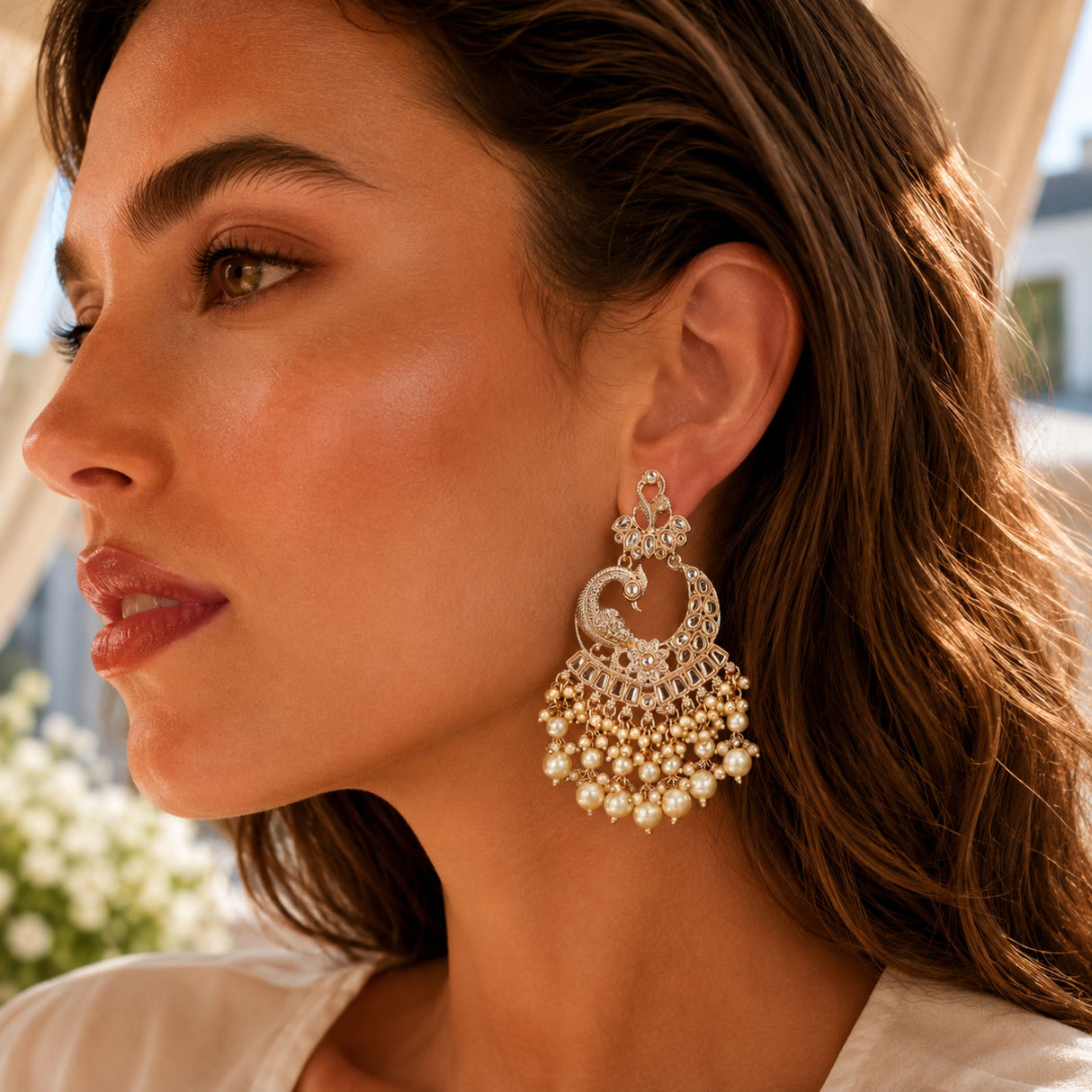 Oversized gold tone peacock kundan chandelier earrings with intricate filigree and cascading faux pearls for ethnic wear