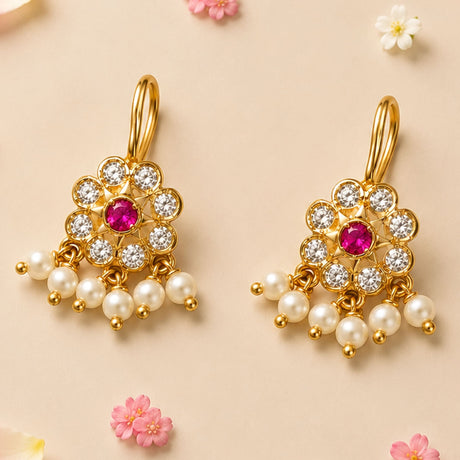 Gold tone kundan chandbali earrings with central ruby, clear crystals, and dangling white faux pearls for diwali and weddings