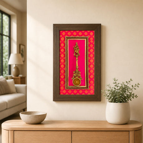 Golden brass decorative dancing krishna deity figurine mounted in a framed display with vibrant red patterned backing